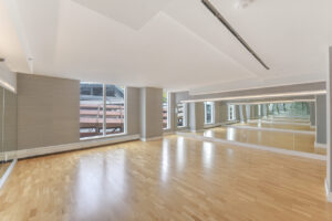 Interior Yoga Studio, wood floors, mirrored walls, floor to ceiling walls, well lit room.