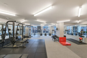 Interior Fitness Center, 3 elliptical machines, 3 treadmills, 2 stationary bikes, kettle bell set, matted floor, weight lifting machine, sit up machine, mirrors on walls, large floor to ceiling windows.